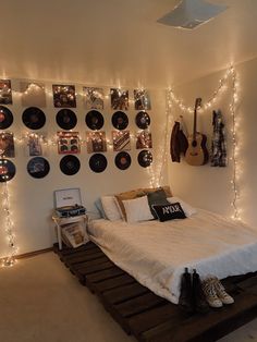 a bed room with a neatly made bed and lots of lights on the wall above it