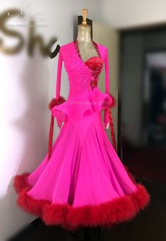 a pink dress with red feathers on display