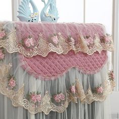 two blue birds sitting on top of a pink and white table cloth covered in tulle