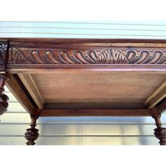 an old wooden table with carvings on the top