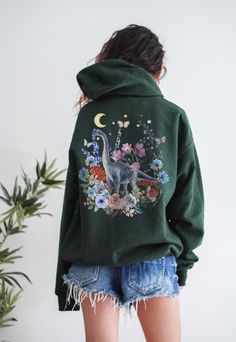 This is a Unisex-Style Watercolor Cottagecore Dinosaur Hoodie. It is a super cool pullover hoodie that is blank on the front with a trendy back print featuring a beautiful collage of a watercolor dino surrounded by botanical and floral illustrations. The soft, warm material is made from a blend of cotton and polyester. It has a front kangaroo-style pocket and no side seams. It is a tried and true hoodie, sure to become your favorite.  SIZE UP 2-3 SIZES FOR THE TRENDY, OVERSIZED LOOK! :) If you need any help with sizing, please don't hesitate to reach out! This design is an original, created by Jillian Anderson @ A Living Whimsy. She uses digital graphic design elements and collage and optimizes each image or illustration for a crisp, clear, and gorgeous print onto a variety of apparel. --I Jillian Anderson, Indie Sweatshirt, Cottagecore Sweater, Indie Clothing, Sweatshirt Aesthetic, Watercolor Elements, Mushroom Fairy, Aesthetic Hoodie, Vintage Illustrations