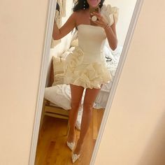 a woman taking a selfie in a mirror wearing a dress with ruffles