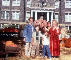 a group of people standing next to each other in front of a house