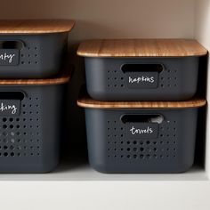 three storage bins with labels on them in a closet