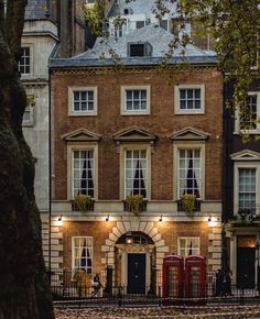 an old brick building with lots of windows and lights on it's front door