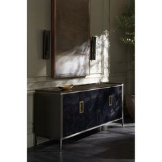 a large mirror hanging on the wall next to a blue cabinet with drawers and doors