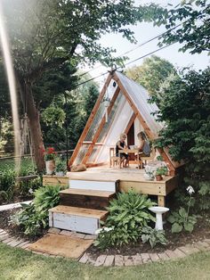 a house built into the side of a tree with stairs leading up to it and people sitting on chairs