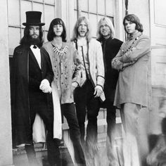 an old black and white photo of four people dressed in costume, standing on steps