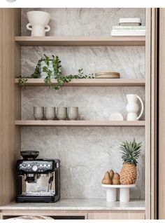 the shelves in this kitchen have pineapples and coffee cups on them, along with other items