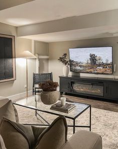 a living room filled with furniture and a flat screen tv mounted on the wall above a fireplace