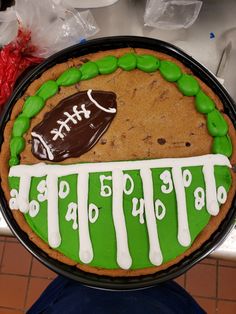 a cookie decorated with green icing and a football on top