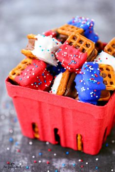 red, white and blue pretzels in a basket with sprinkles