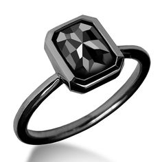 a black diamond ring sitting on top of a white surface