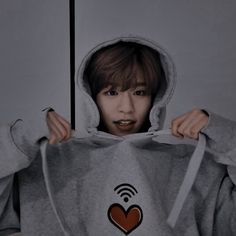 a person wearing a gray hoodie with a red heart on it