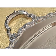 an ornate silver tray on a gold cloth