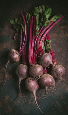 beets and other vegetables on a table with dark brown grungy background, top view