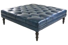 a blue leather ottoman with wooden legs