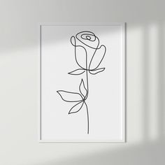 a black and white drawing of a single rose on a white wall in a room