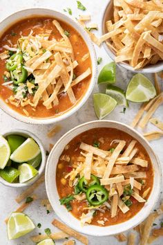 three bowls of chili soup with tortilla chips and limes on the side