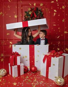 two children are standing in front of presents