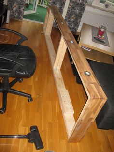 an office chair is sitting on the hard wood floor next to a wooden desk and shelf