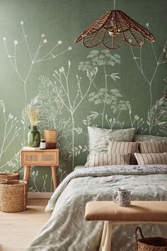 a bedroom with green walls and white flowers on the wall, along with a bed