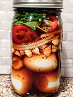 a jar filled with food sitting on top of a counter next to a tile wall