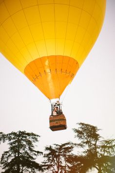 two people in a hot air balloon flying through the sky