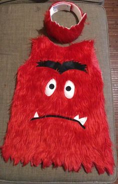 a red furry bag sitting on top of a floor next to a pair of scissors