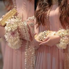 two women in pink dresses holding flowers and clutches on their hands, both wearing gold jewelry