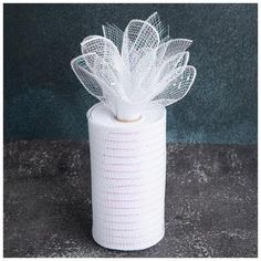 a roll of toilet paper with a white flower on it's top and mesh netting around the edge