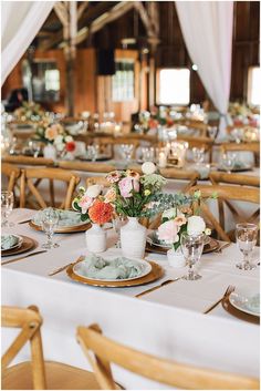 the tables are set with flowers in vases and place settings for guests to sit at