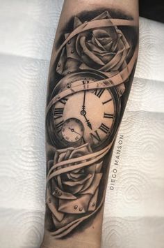 a black and white photo of a clock with roses on the inside of it's arm