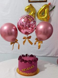 a birthday cake with pink and gold balloons