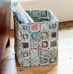 a multicolored storage bin with magazines inside it on a white background, showing the bottom section