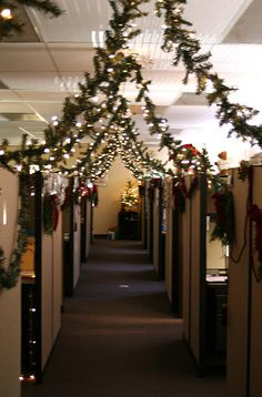 an office hallway decorated for christmas with garland and lights