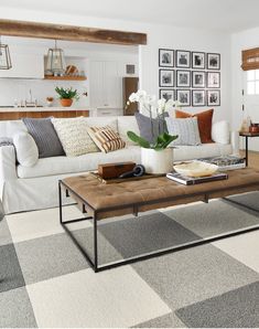 a living room filled with furniture and pictures on the wall above it's coffee table