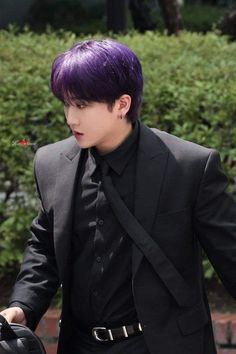 a man with purple hair wearing a suit and tie