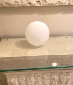 a white ball sitting on top of a glass shelf