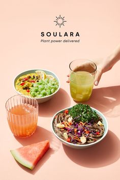 there is a bowl of salad and a glass of juice on the table with watermelon