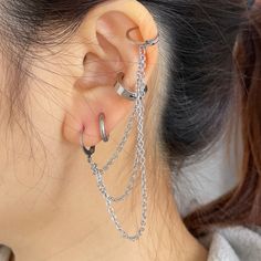 a close up of a person wearing ear rings with chains attached to the back of their ears