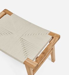 an upholstered wooden bench with white fabric on it