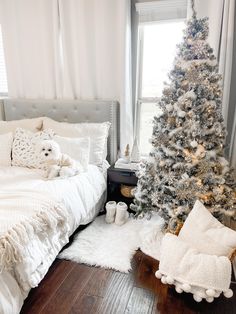 a bedroom decorated for christmas with a white tree and fluffy rugs on the floor