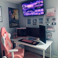 a computer desk with a monitor, keyboard and mouse on it in front of pictures