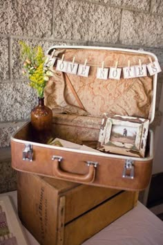 an old suitcase with clothes hanging from it