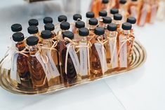 several bottles of different types of liquid on a tray with tags tied around the bottles