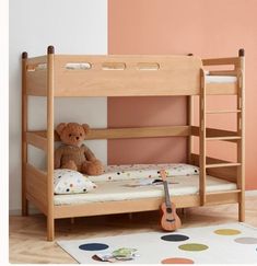 a teddy bear sitting on top of a bunk bed next to a rug and wall