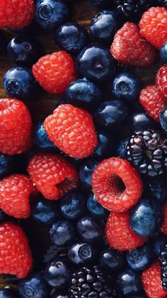 berries, raspberries and blueberries on a wooden surface