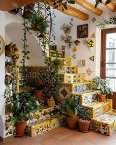 there are many potted plants on the stairs in this room with yellow and green tiles