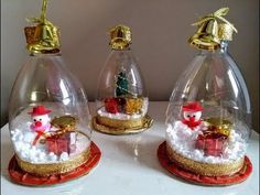 three snow globes sitting on top of a table with christmas decorations in them,